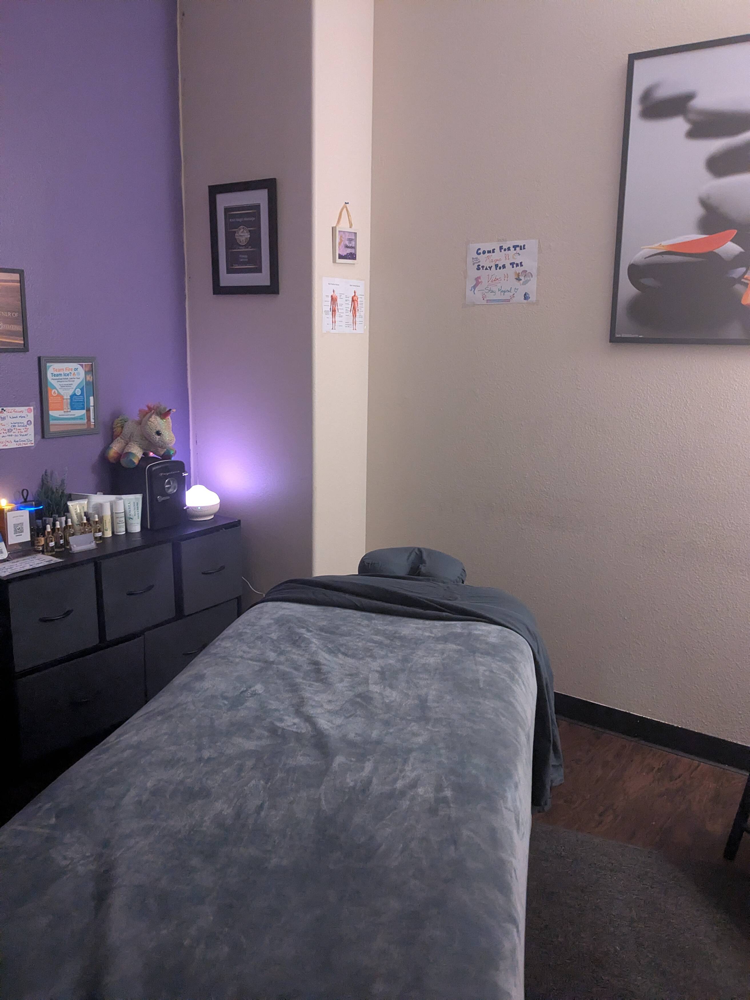 The real Magical Knot Massage treatment room with its lavender wall and plush massage table
